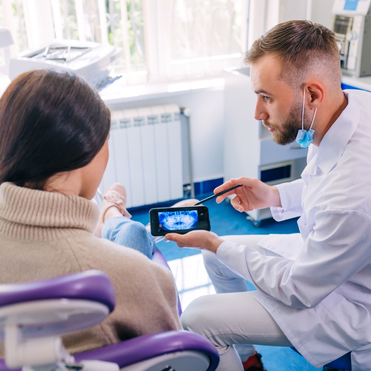 A dentist using the OrthoPhoto app on his phone